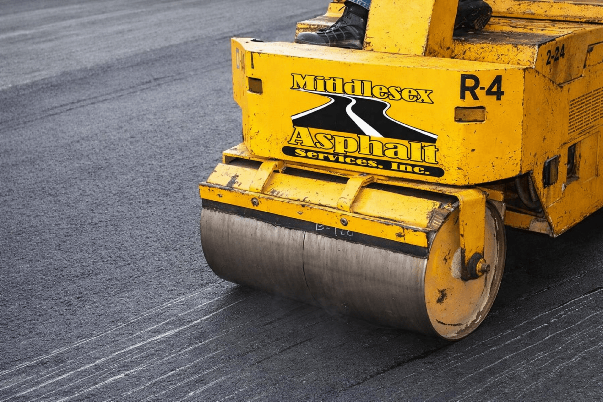Road roller compacting fresh asphalt