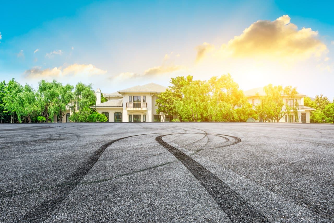 Wide asphalt parking area in front of residential apartment buildings